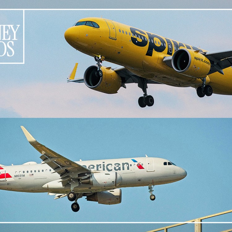 A Spirit Airlines plane and an American Airlines plane flying in the sky.