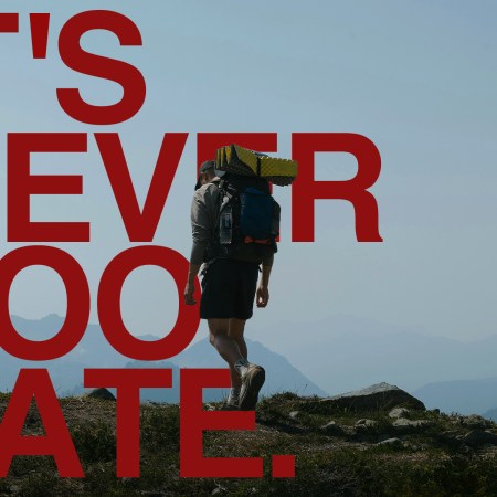 A man rucking on a trail with a backpack filled with weights. Over top, there is text that reads: It's Never Too Late.