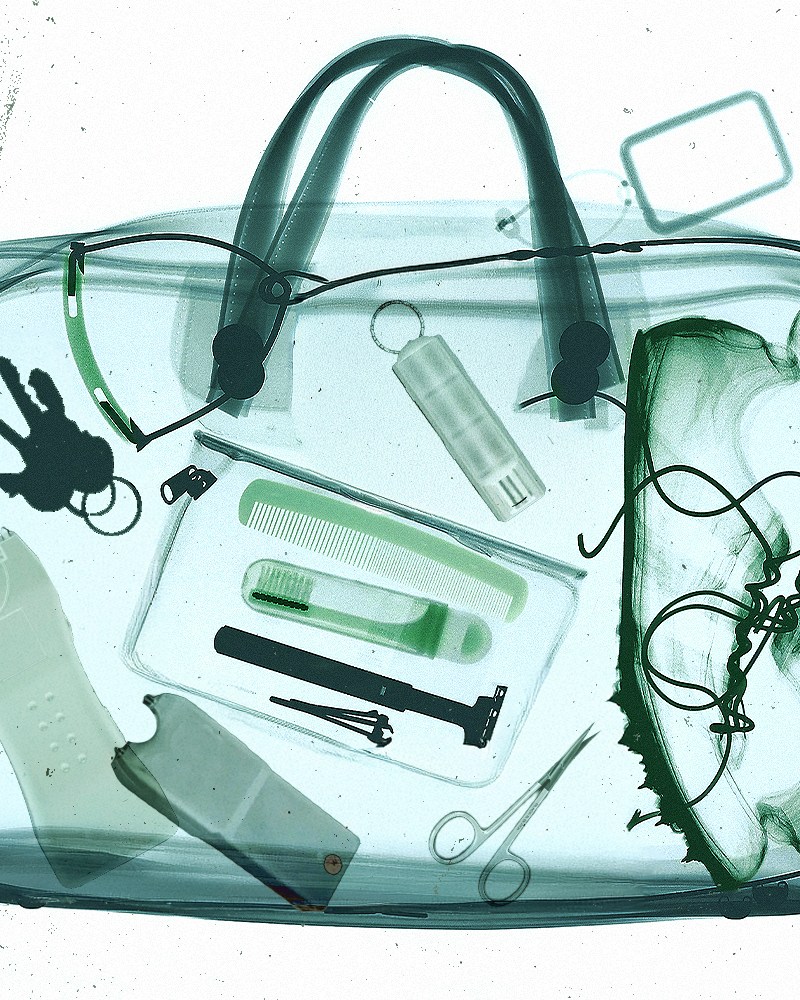 X-ray image of a duffel bag showing multiple prohibited items inside, including liquids and other flagged objects, highlighted during airport security screening.