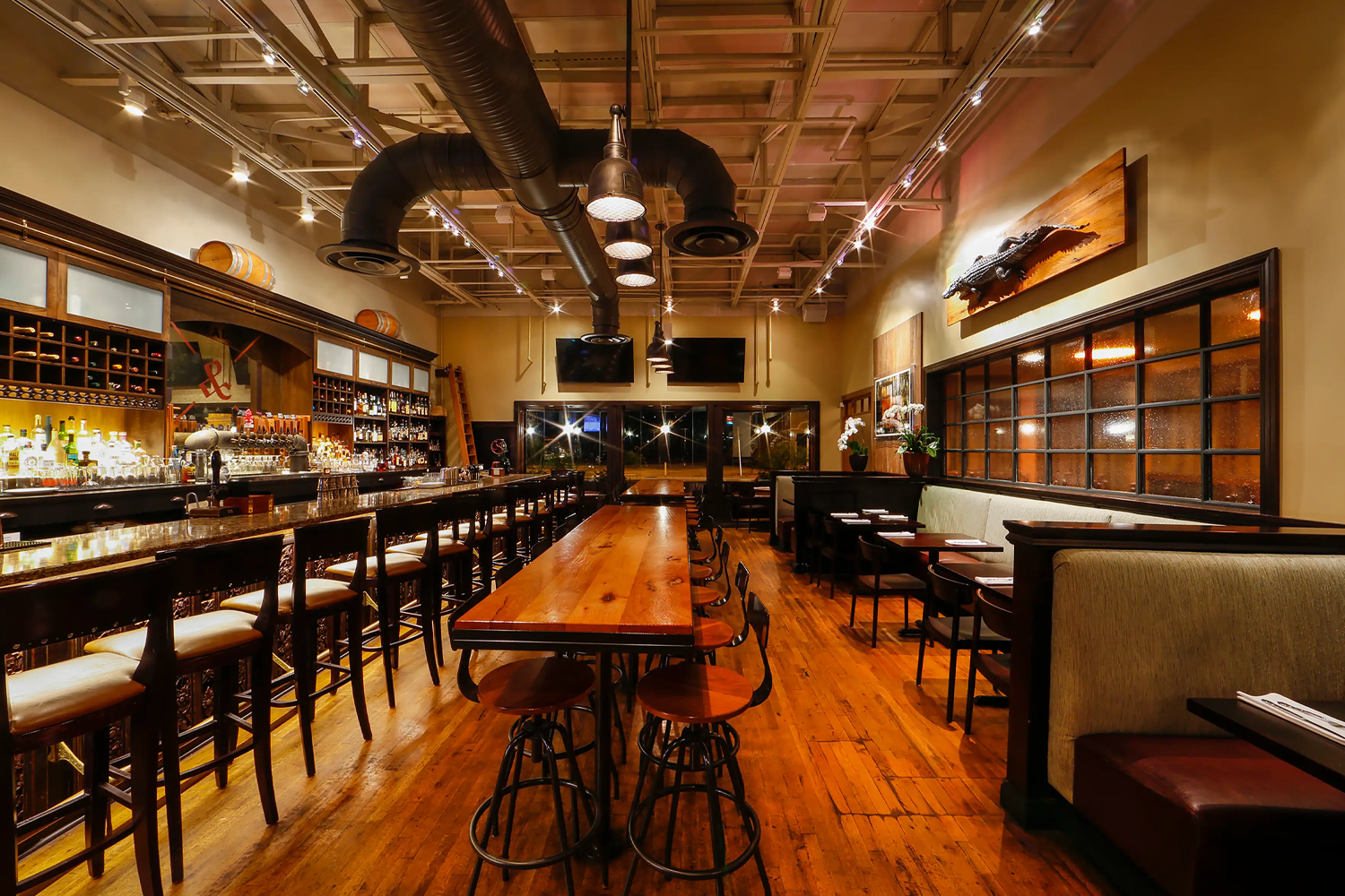 Restaurant interior at The Ravenous Pig featuring a contemporary gastropub dining room with warm lighting, wood accents, a bar area and tables set for guests.