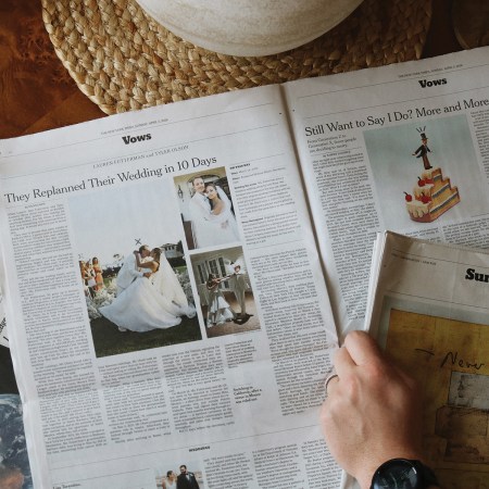 A person flipping through the Vows section of "The New York Times" that features wedding announcements