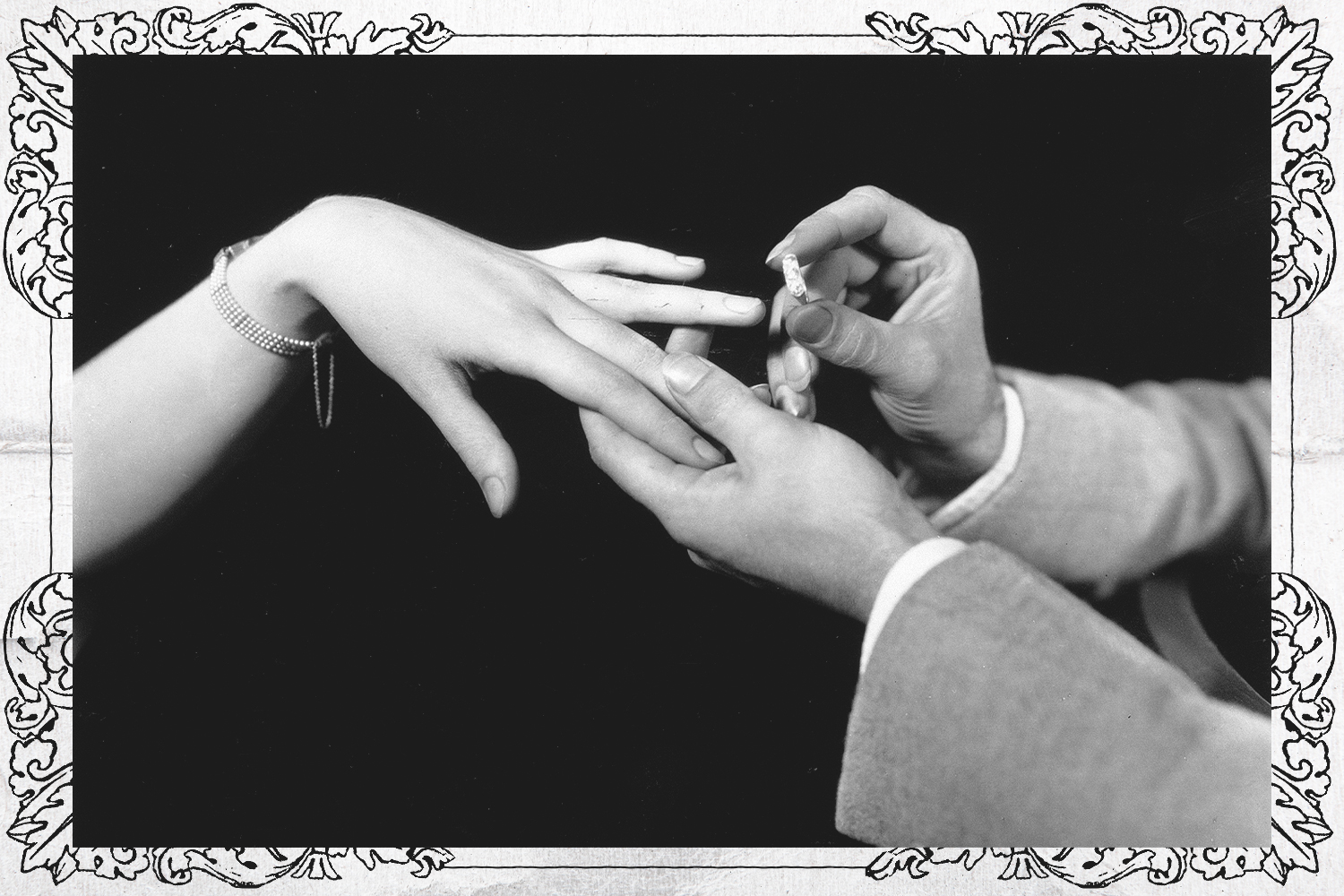 A man placing a diamond engagement ring on the hand of a woman