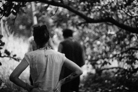 A woman standing behind a man walking in front of her