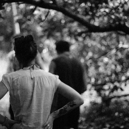 A woman standing behind a man walking in front of her