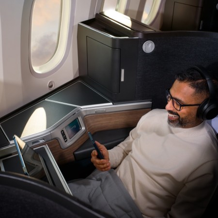 Man on plane watching his phone