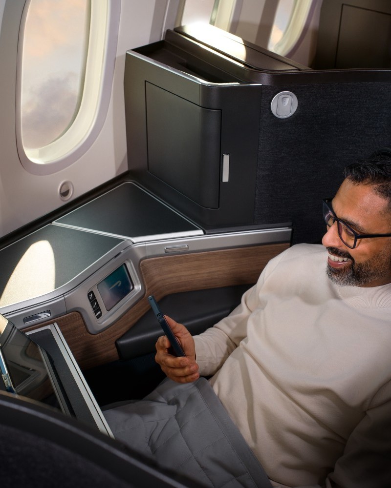 Man on plane watching his phone