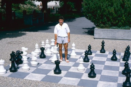 Man standing on a life-sized chessboard.