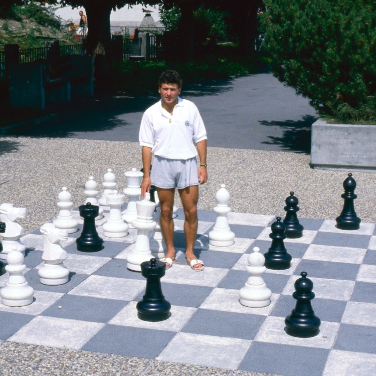 Man standing on a life-sized chessboard.