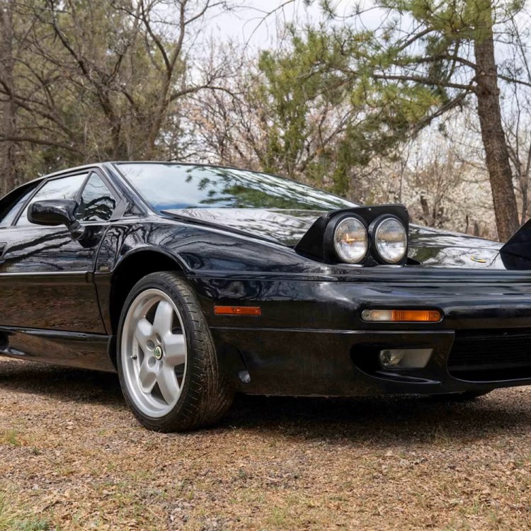 A black car in the foreground with a red, white and orange taillight behind it