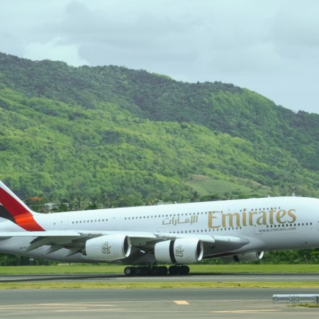 Emirates flight landing against a green background