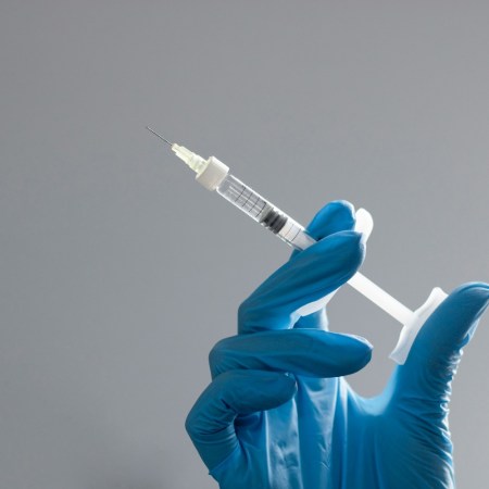 Hand in surgical glove holding needle