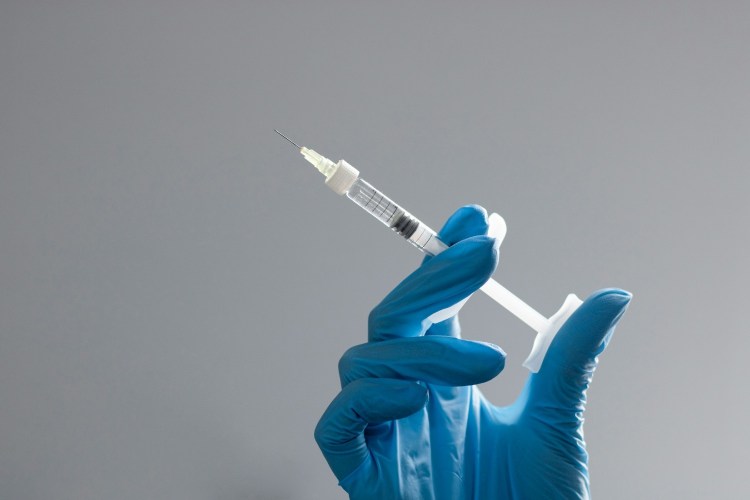 Hand in surgical glove holding needle