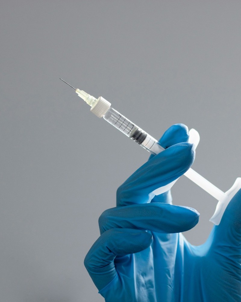 Hand in surgical glove holding needle