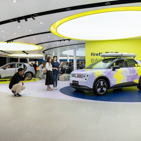 People looking at an EV at an auto show