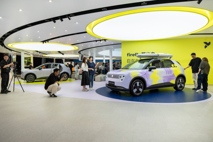 People looking at an EV at an auto show