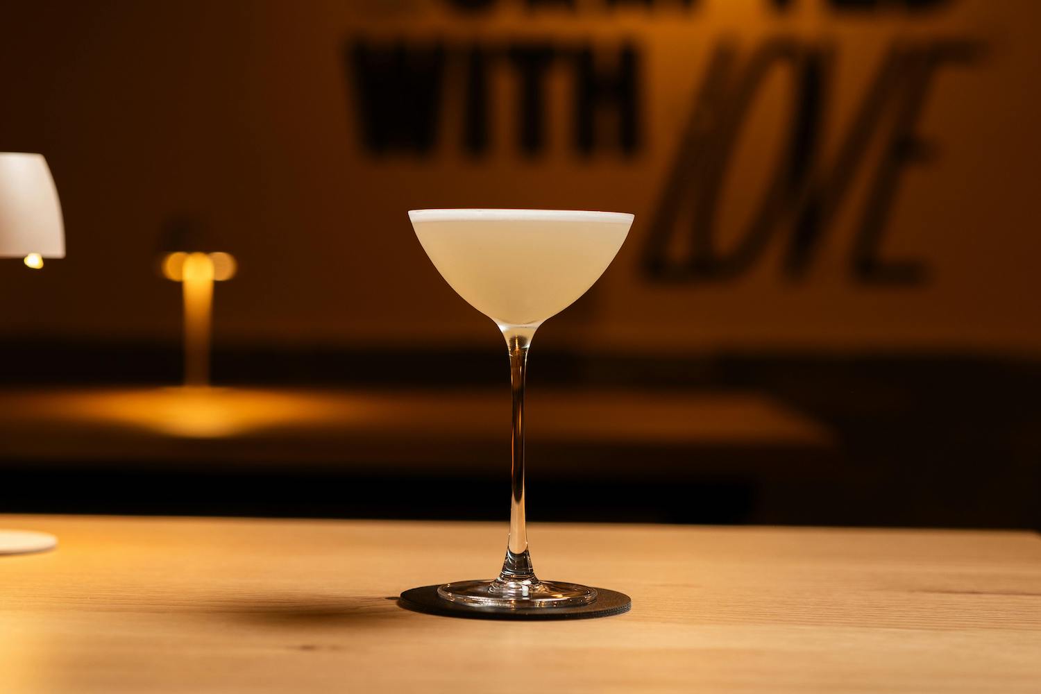 Elegant Cocktail on Wooden Table in Dimly Lit Bar