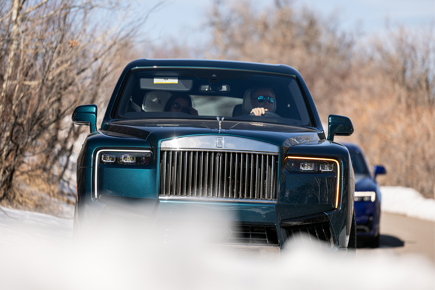 A man in sunglasses behind the wheel of an SUV