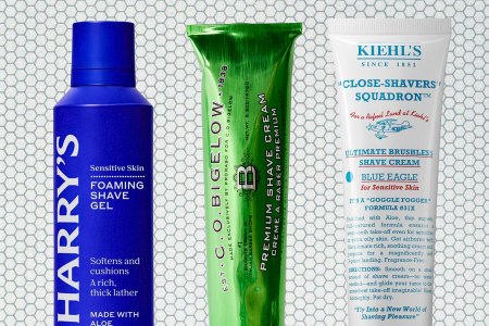 A blue bottle, a green tube and a white tube on a tile background