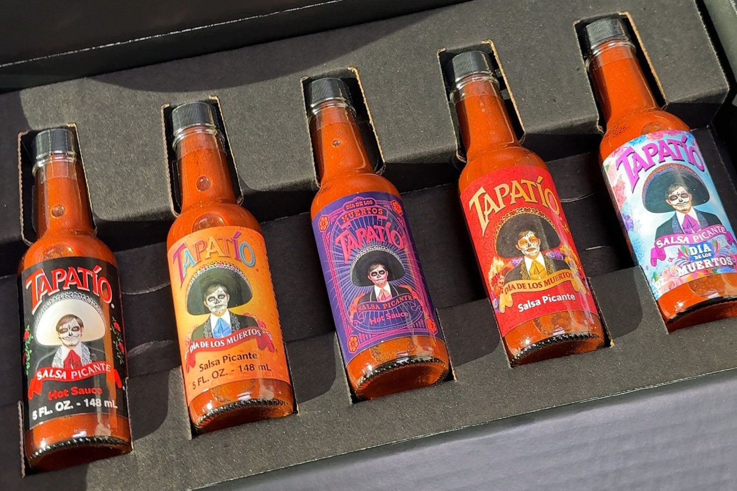 A box of bottles of Tapatio hot sauce