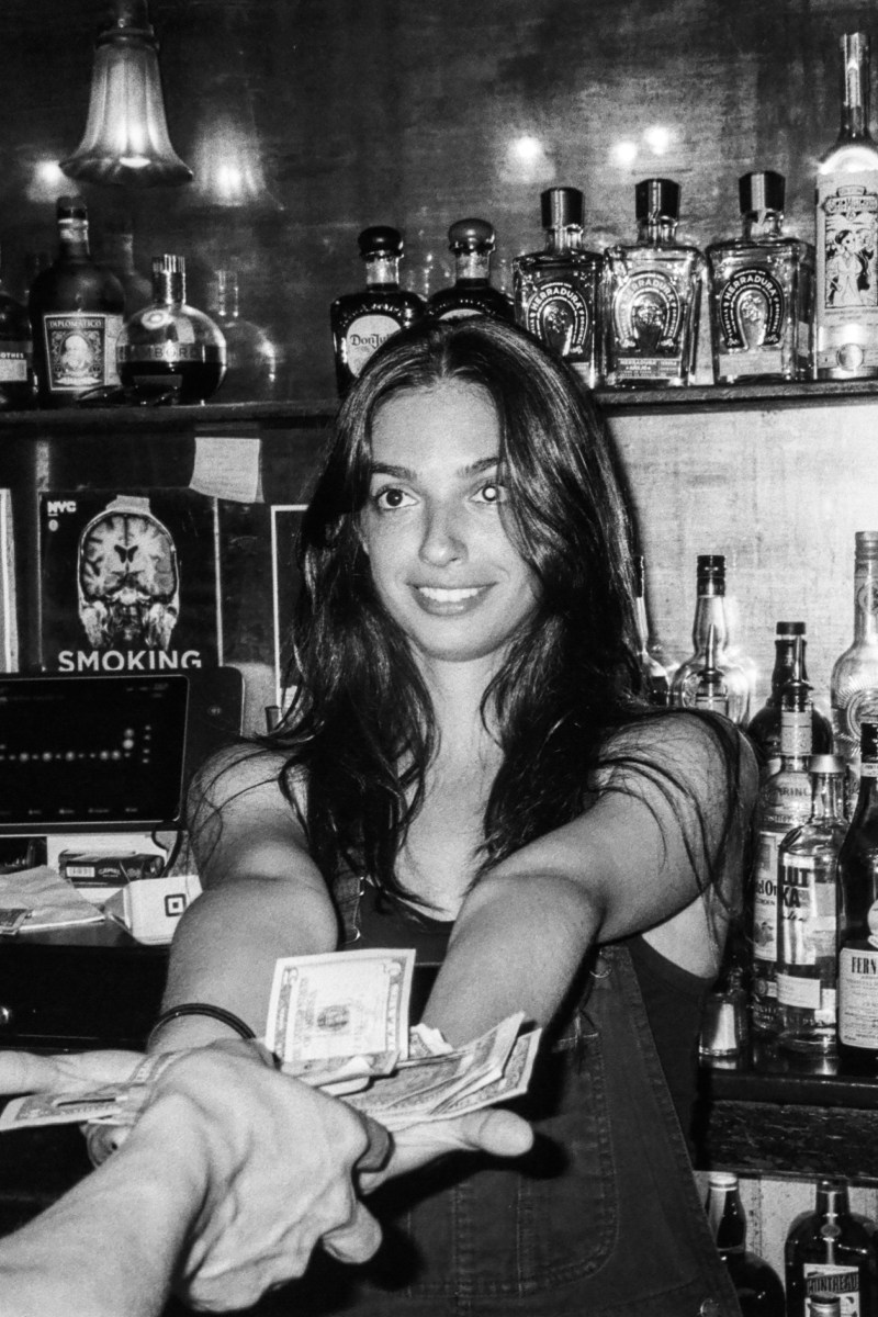 A woman standing behind a bar