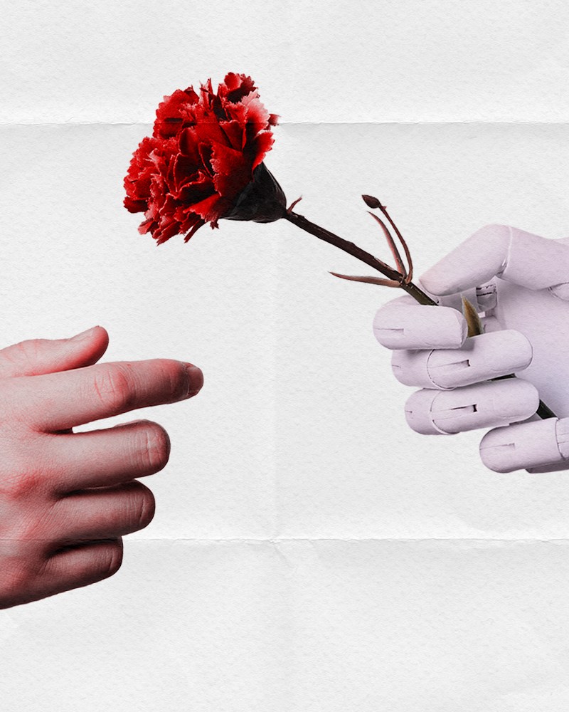 A human hand extending to reach for a rose being given by a robot hand