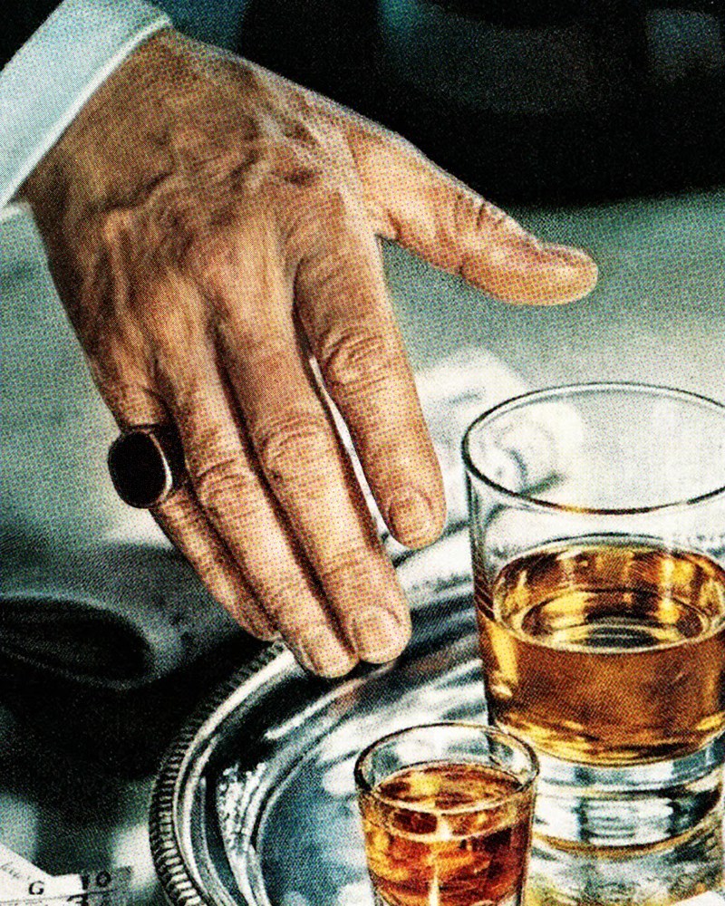 A man reaching for a glass of whiskey