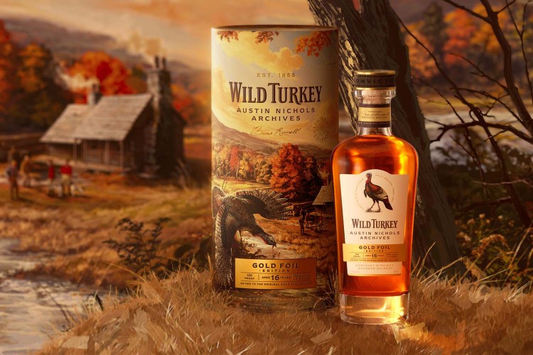 A bottle of whiskey sitting next to a cylindrical container with a barn illustration in the background