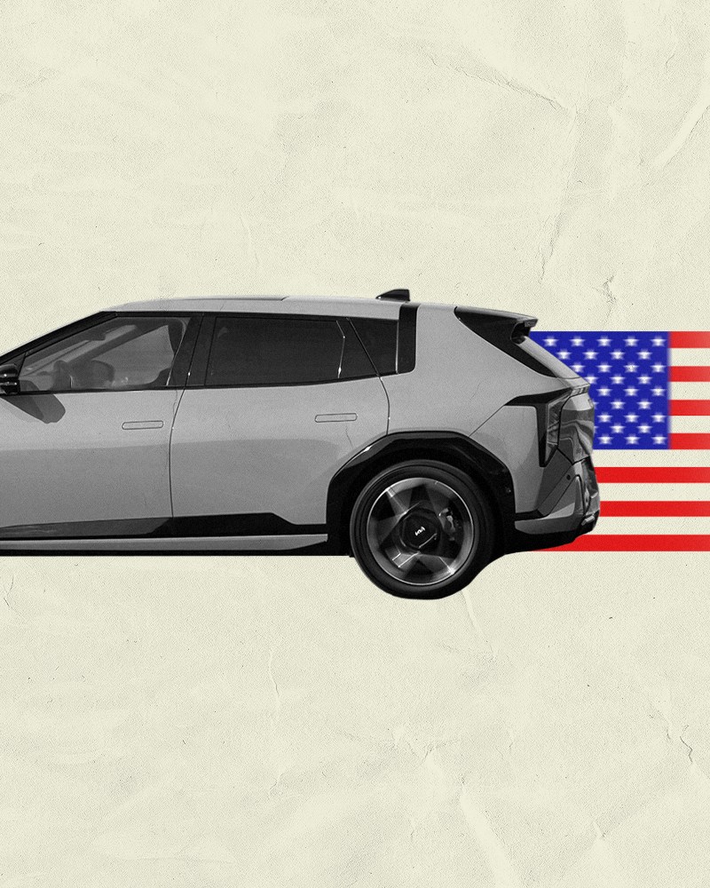 A gray and black car driving to the left with an American flag trailing behind it fading into a beige background