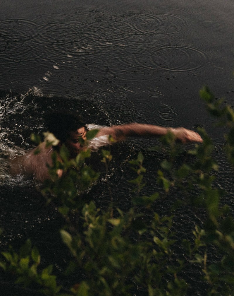 A man swimming in a pond.