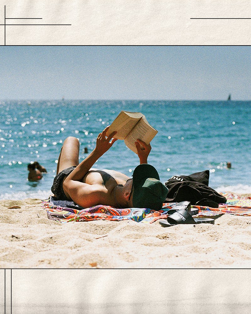 A man reading a book on the beach