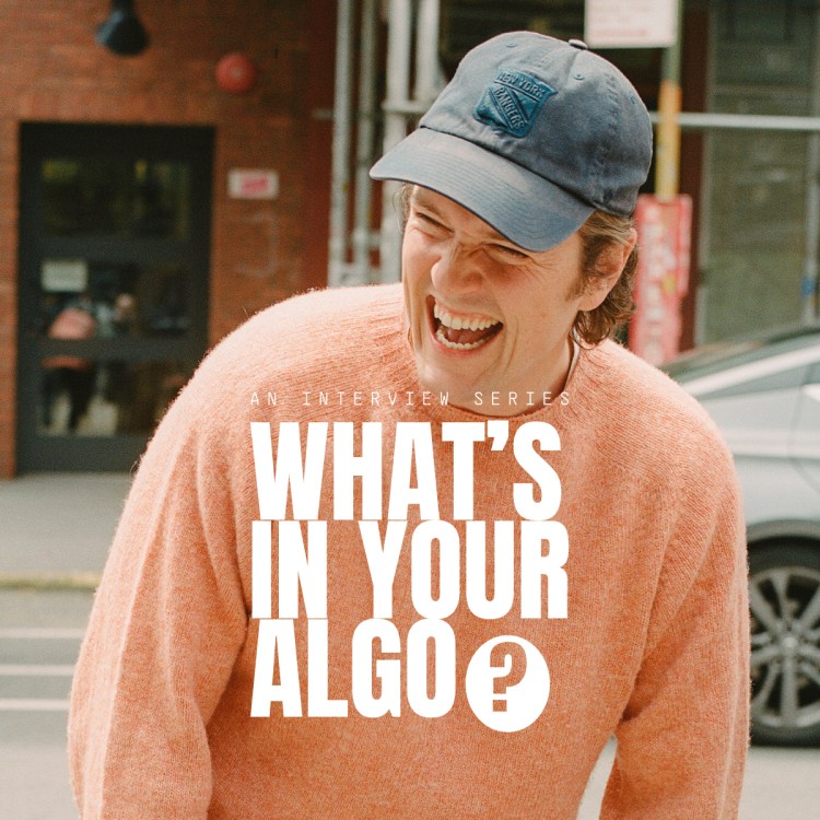 A man in a peach sweater with a New York Rangers baseball cap laughing, with the text "What's in Your Algo?" over the top