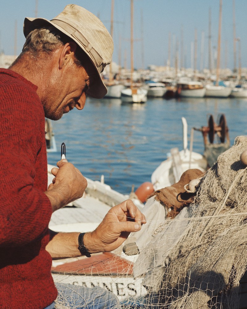 A fisherman tinkering with his nets.