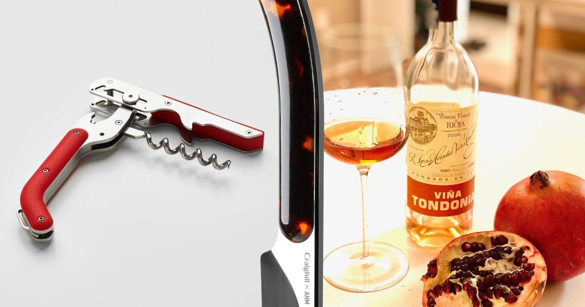 A wine key with a red handle on the left, a Champagne saber in the middle, and on the right a table with a bottle of wine, a wine glass and a pomegranate cut in half to show the seeds
