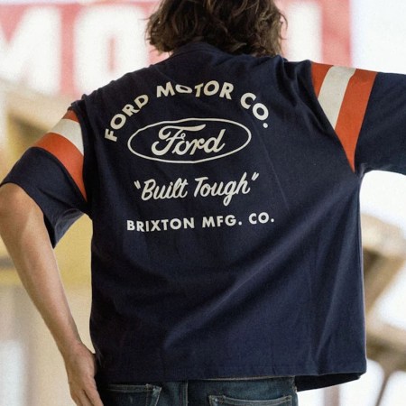 A model in a blue shirt with a Ford x Brixton logo on the back