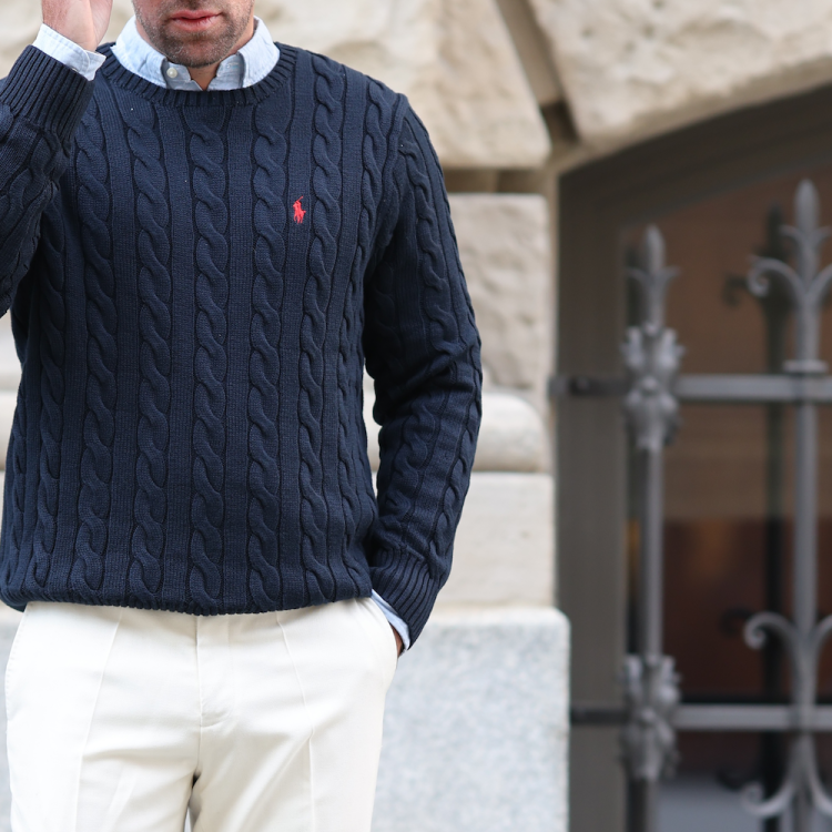 A model in a navy cable-knit Polo Ralph Lauren sweater.