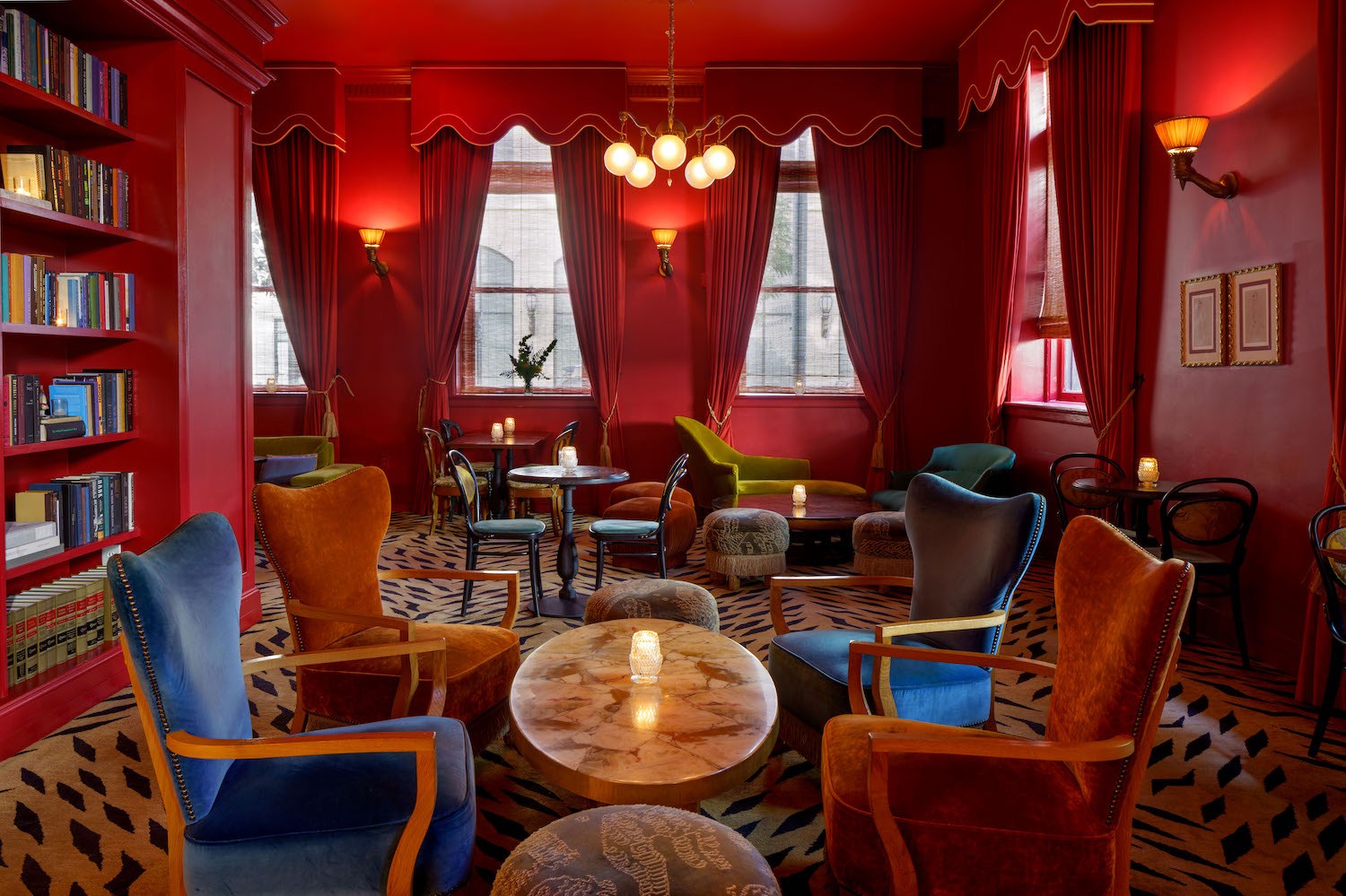 a red room with animal print carpet and blue and yellow velvet chairs
