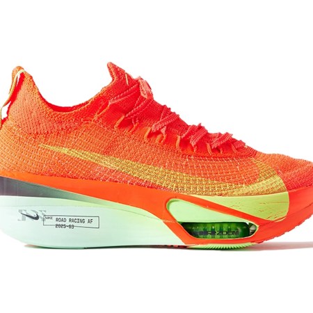Bright orange and yellow knit running shoe with a thick, mint green sole and visible green Zoom Air units.