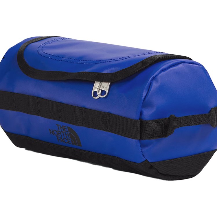 A cylindrical blue North Face duffel bag with black straps and zipper, angled on a white background.