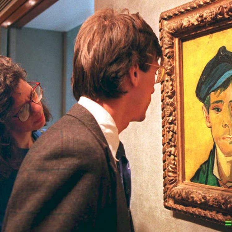 Two people, a man and a woman, look at a framed painting of a man with a blue cap and green jacket.