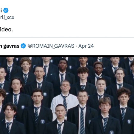 A screenshot of a tweet from Charli XCX featuring an image of a large group of young men in dark blazers and striped ties, one man in a white shirt stands out.