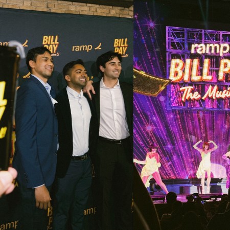 Three men pose on a red carpet next to a stage with performers and a "Ramp Bill Pay The Musical!" sign.