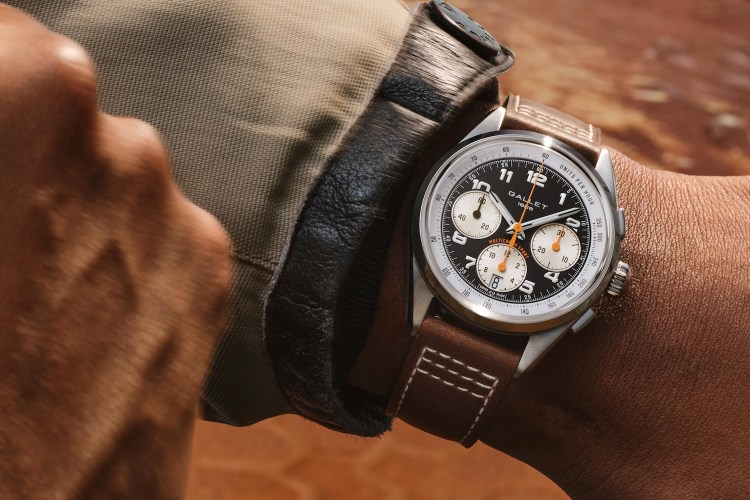 Wrist wearing a Gallet 1826 Multichron Sport watch with a black face, white subdials, and a brown leather strap.