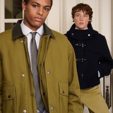Two young men in fall coats: one in olive green with a tie, another in a navy duffle coat.