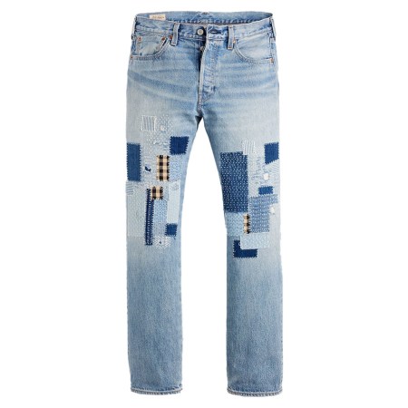Light-wash denim jeans with various blue and black-and-white checkered patches on the thighs and knees.