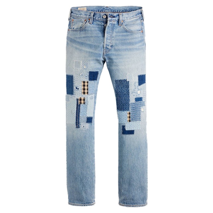Light-wash denim jeans with various blue and black-and-white checkered patches on the thighs and knees.