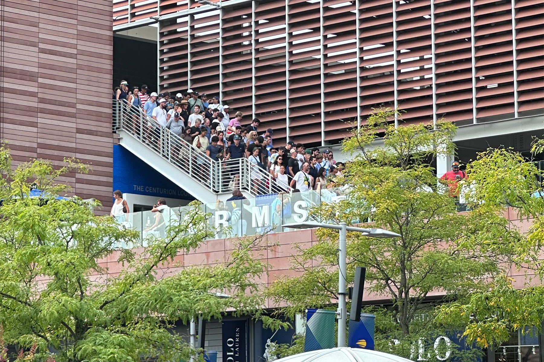a hoard of people walking down the stairs at louis armstrong stadium