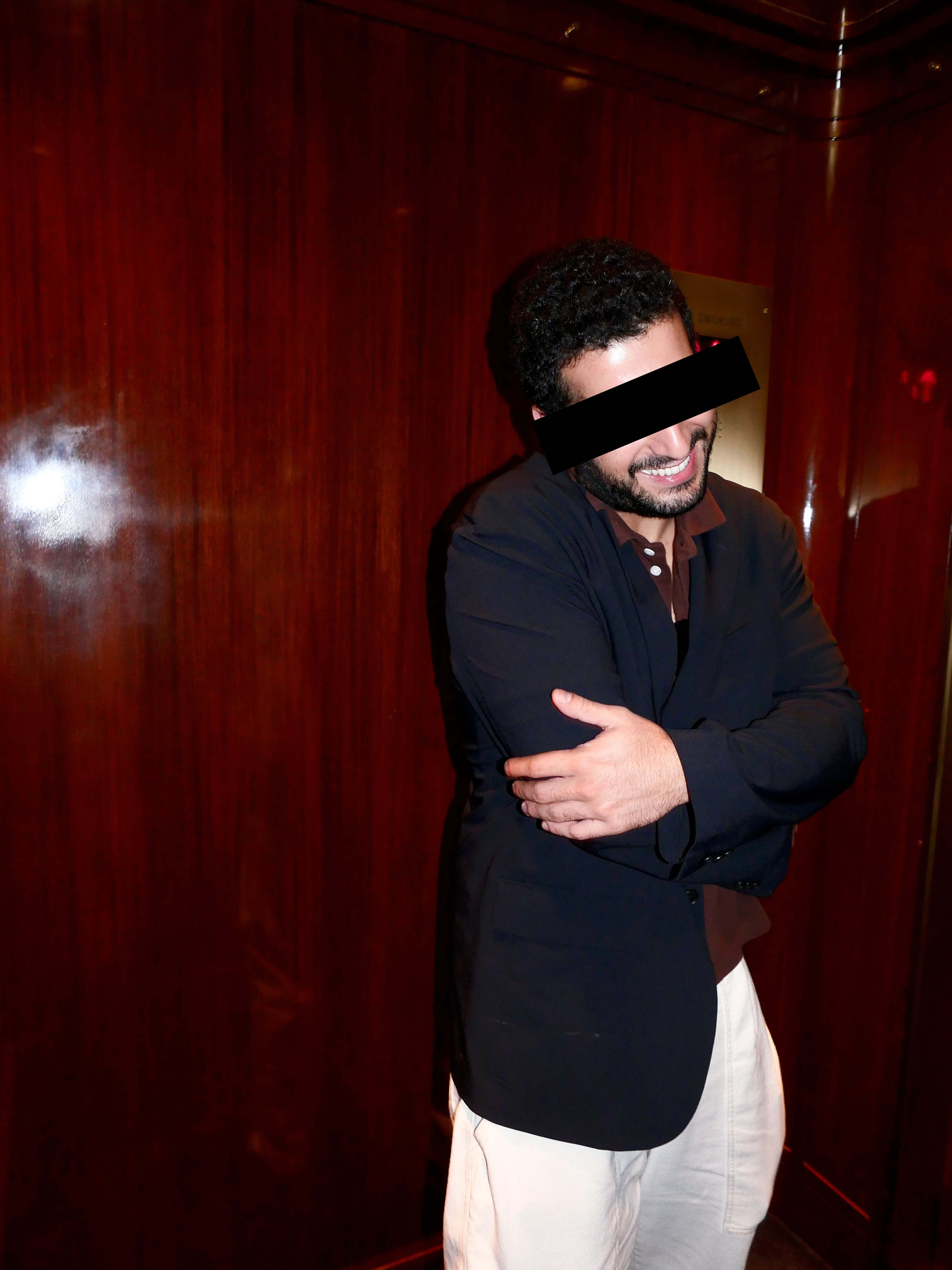Mikey smiling and crossing his arms in the Casa Cipriani elevator.