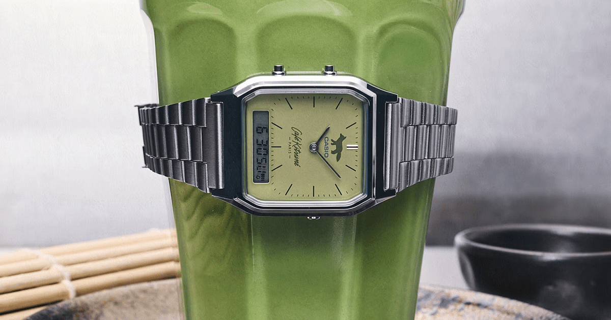Silver Casio watch with a green face and fox logo, wrapped around a glass of green matcha tea.