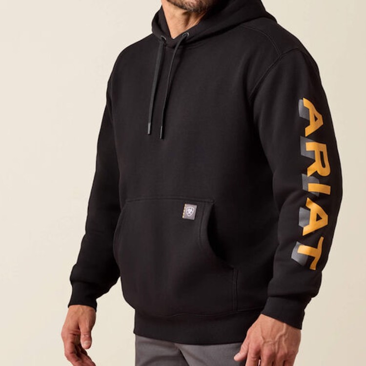 Man in a black hoodie with "ARIAT" in gold and gray on the left sleeve, and a small logo on the pouch.
