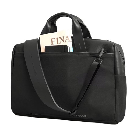 Black Troubadour briefcase with a "FINANCIAL" magazine and notebook in an outer pocket.